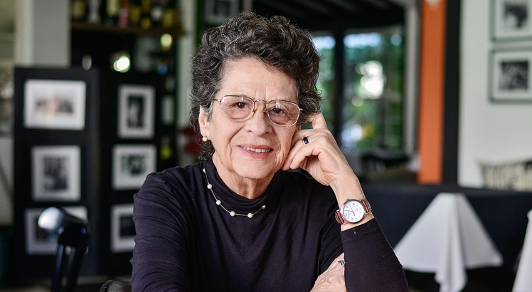 escritora Maria Valéria Rezende sorrindo com o rosto apoiado na mão